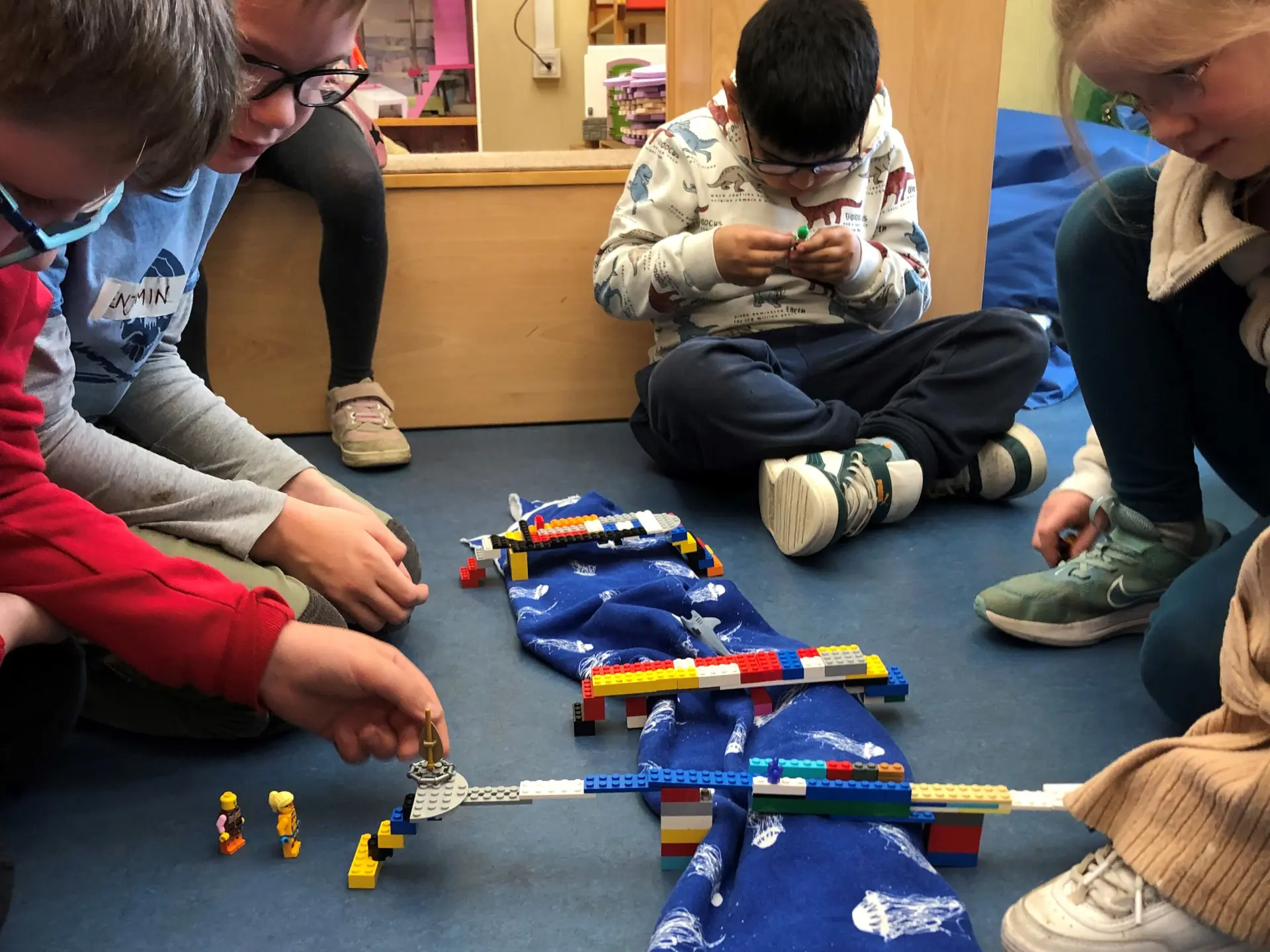 Kinder bauen gemeinsam Lego-Brücken
