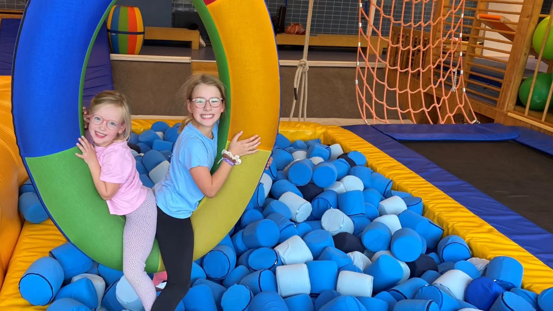 Kinder sitzen auf einem Schwungreifen