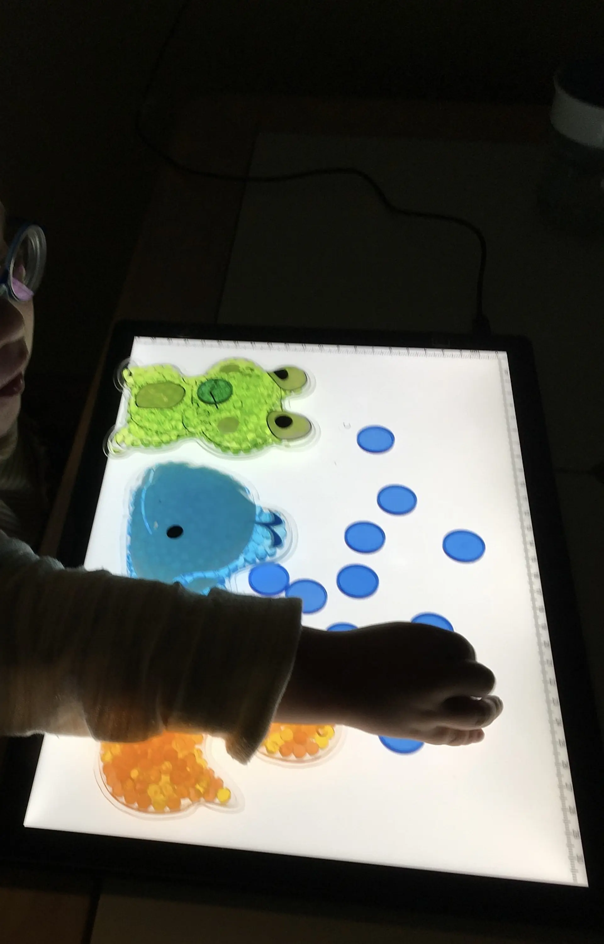 Wahrnehmungsförderung: Leuchttisch mit transparenten, leuchtenden Spielmaterialien zur Schulung der visuellen Wahrnehmung, Farberkennung und Feinmotorik in der Frühförderung.