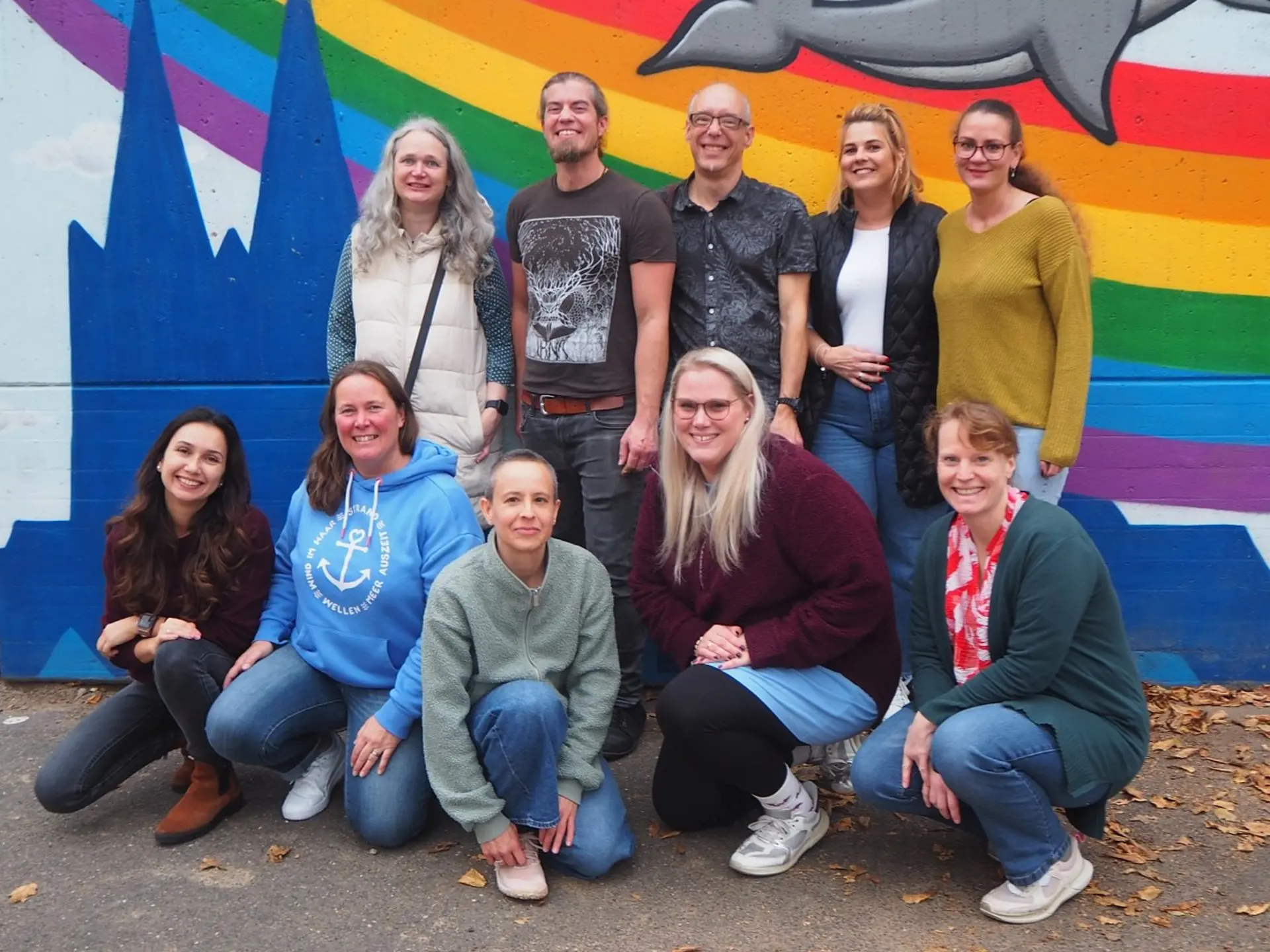 Gruppenbild der Schulpflegschaft vor einer bunten Wand im Schulhof der LVR-Severin-Schule