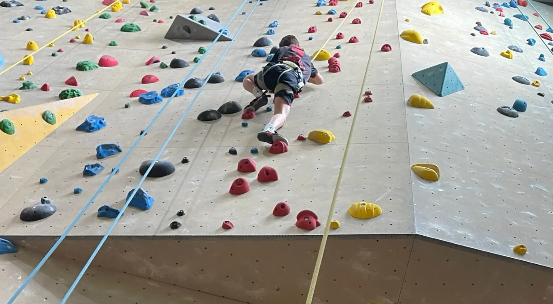 Ein Kind klettert eine Kletterwand hoch