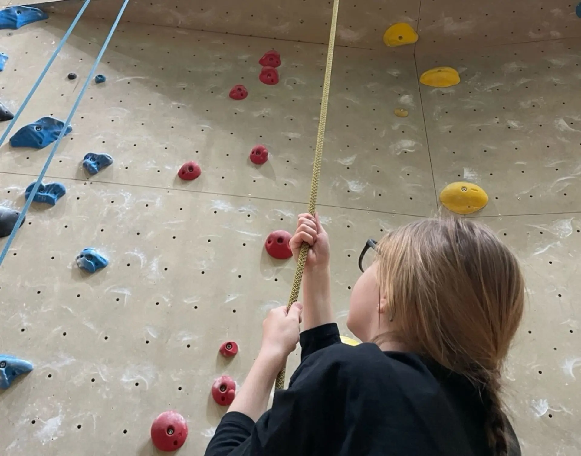 Schülerin klettert an Kletterwand 