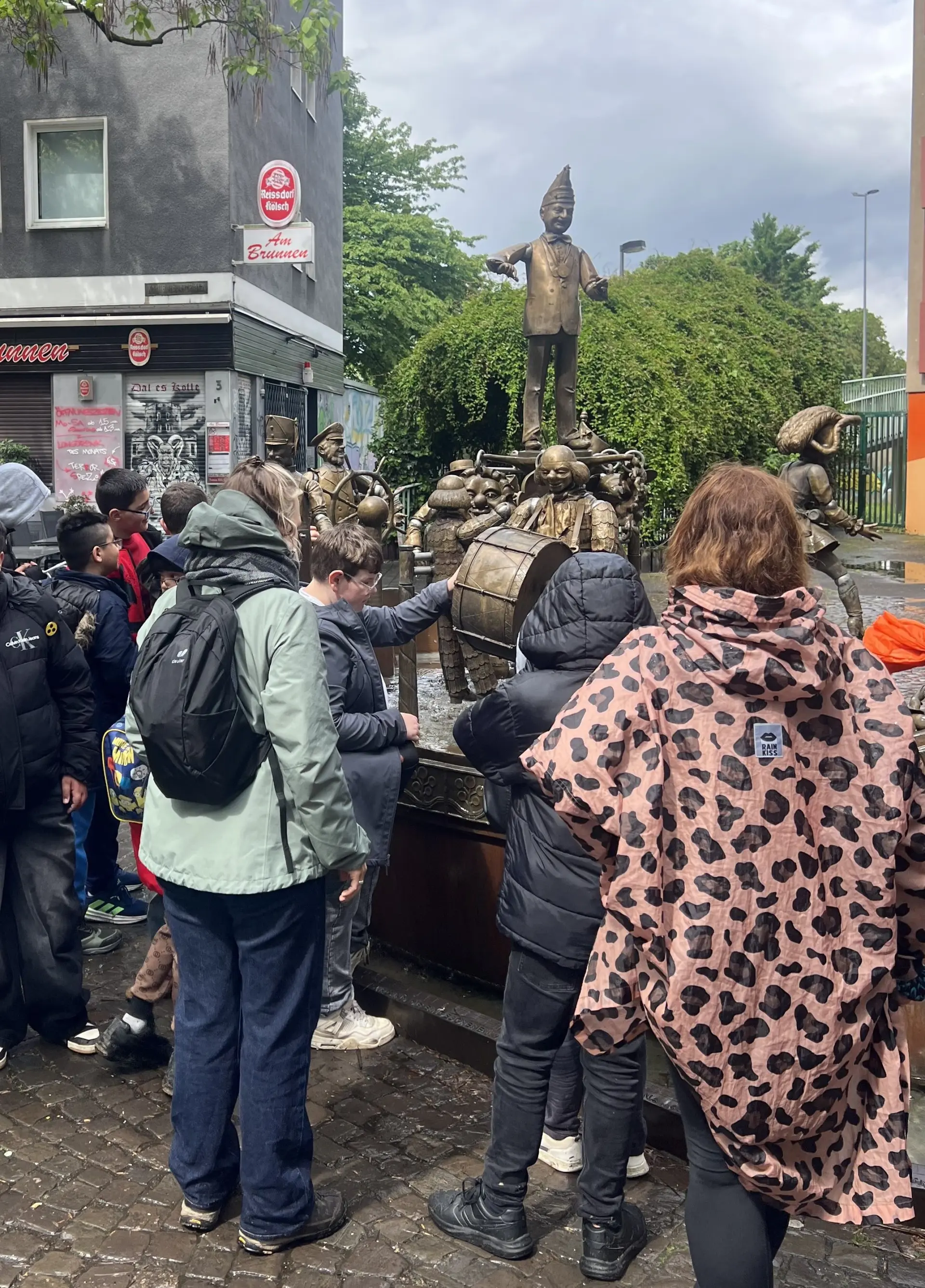 Schüler*innen stehen vor einer Statur